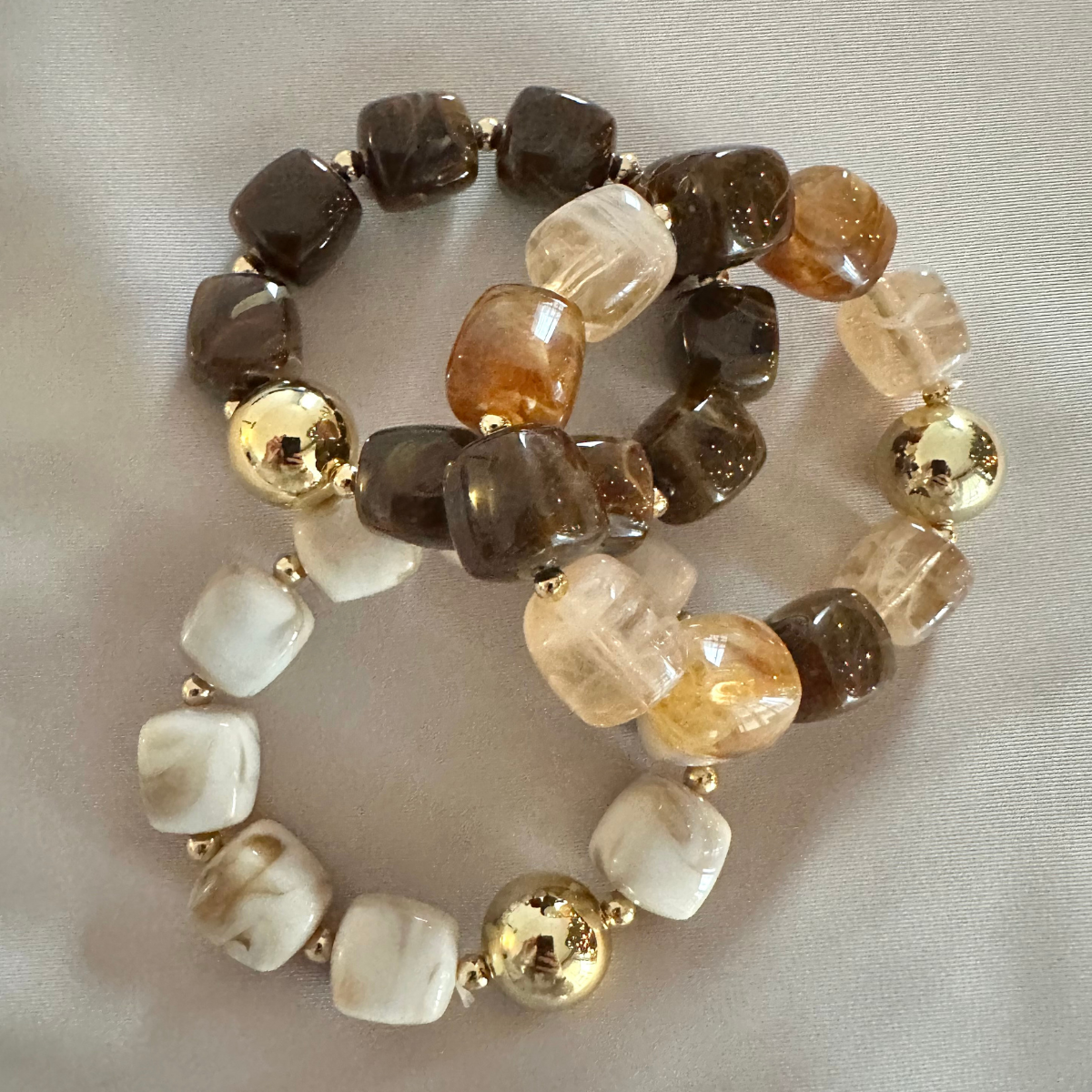 Set van 3 kralenarmbanden in de kleuren bruin, beige en goud. 