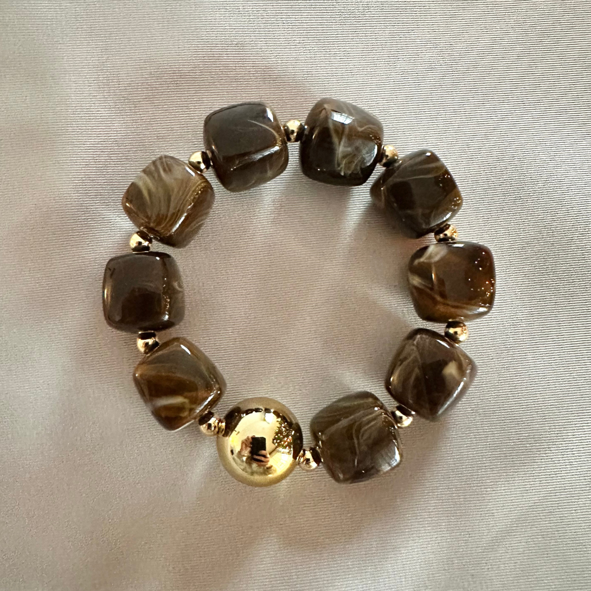 Bruine kralenarmband met een gouden kraal voor dames.